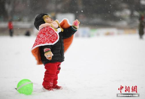 资料图：2月12日，北京迎来今冬第二场降雪，一名幼童仰头感受雪花纷飞。<a target='_blank' href='http://www.chinanews.com/'>中新社</a>记者 赵隽 摄